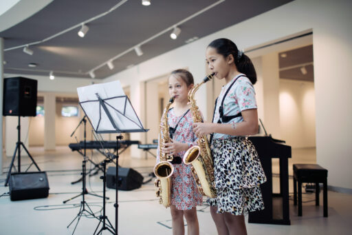 Twee meisjes spelen op een saxofoon